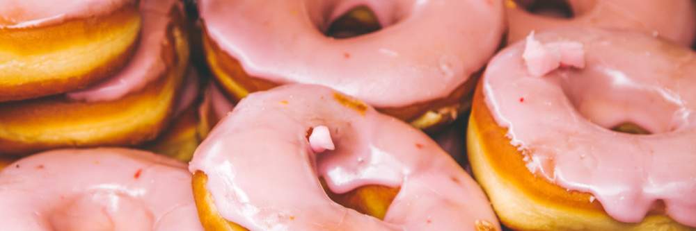 a pile of donuts with pink icing