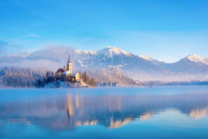 Lake Bled on a sunny winter morning with snow on mountains