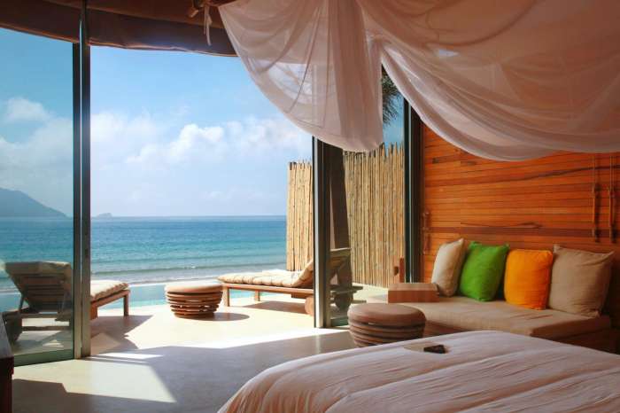 Two sunloungers on the terrace of a wood-clad room looking out to sea
