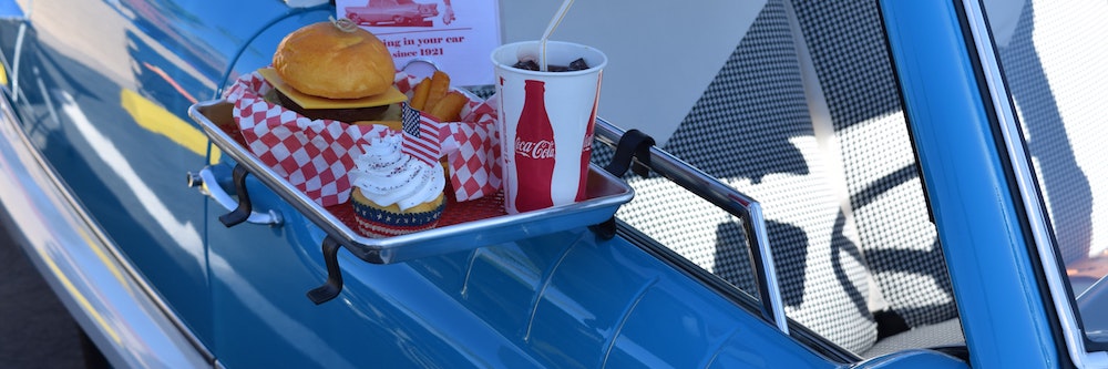 Fast food next to a retro car at a drive in
