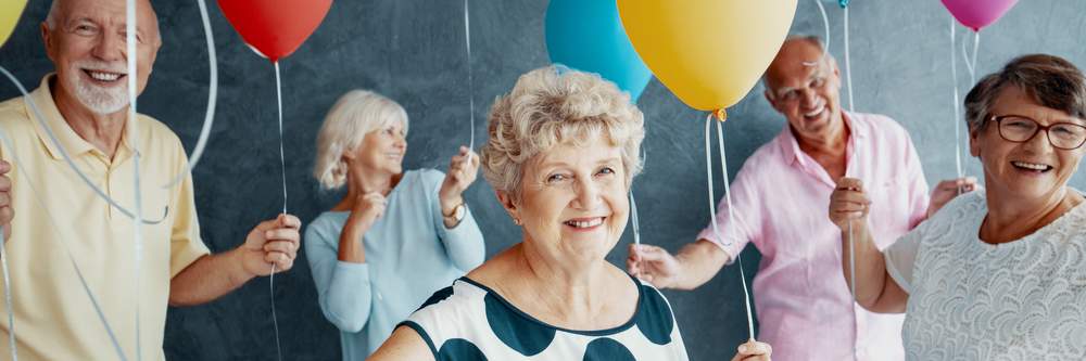 elderly people laughing with balloons