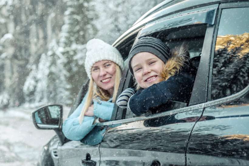 mother and daughter smiling out of car windows