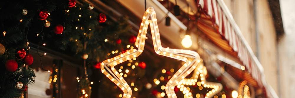 photo of christmas star shaped lights outside of a shop in London with holly in the background