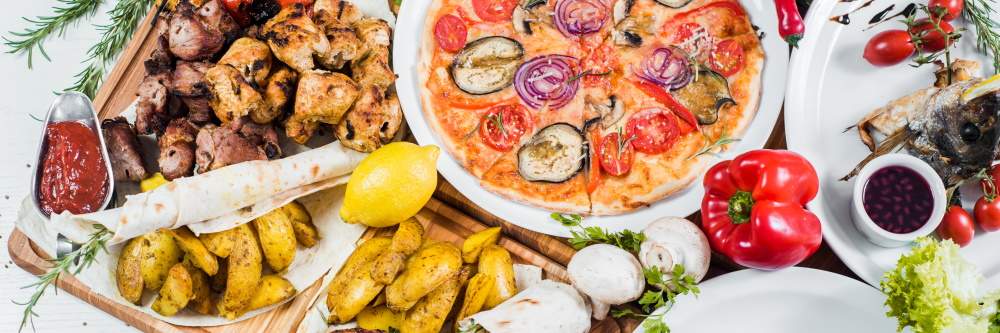 photograph of a variety of cuisines from around the world, including pizza, fries, and Lebanese food