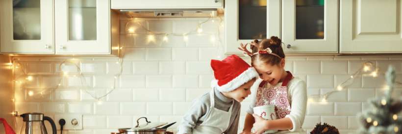 children doing christmas baking wearing santa hats